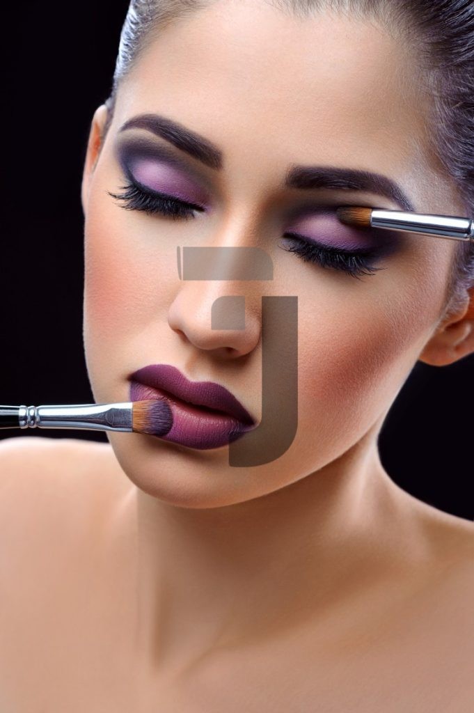 عکس باکیفیت زن جوان در حال انجام میکاپ