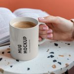 فایل لایه باز موکاپ لیوان دسته دار روی میز از نمای بالا